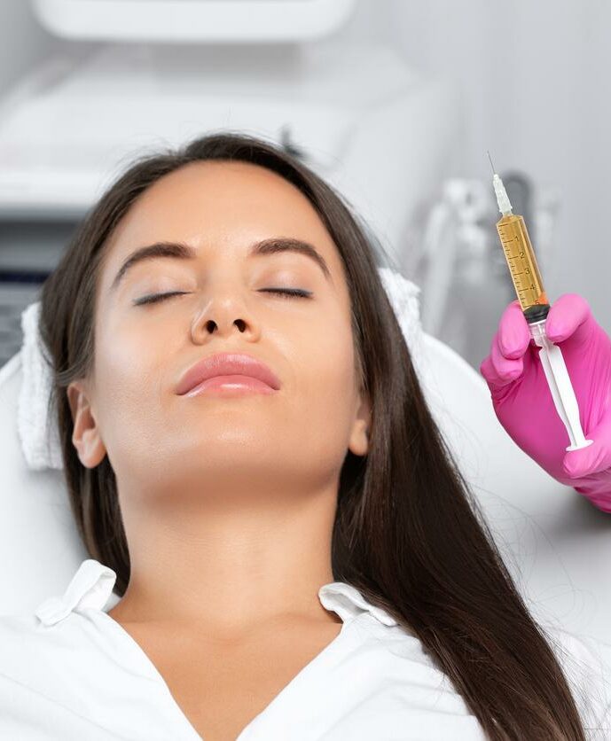 Beautician will do PRP therapy for the face against wrinkles
and against hair loss of a beautiful woman in beauty salon.Doctor holds test tubes with venous blood and blood plasma.Cosmetology concept.